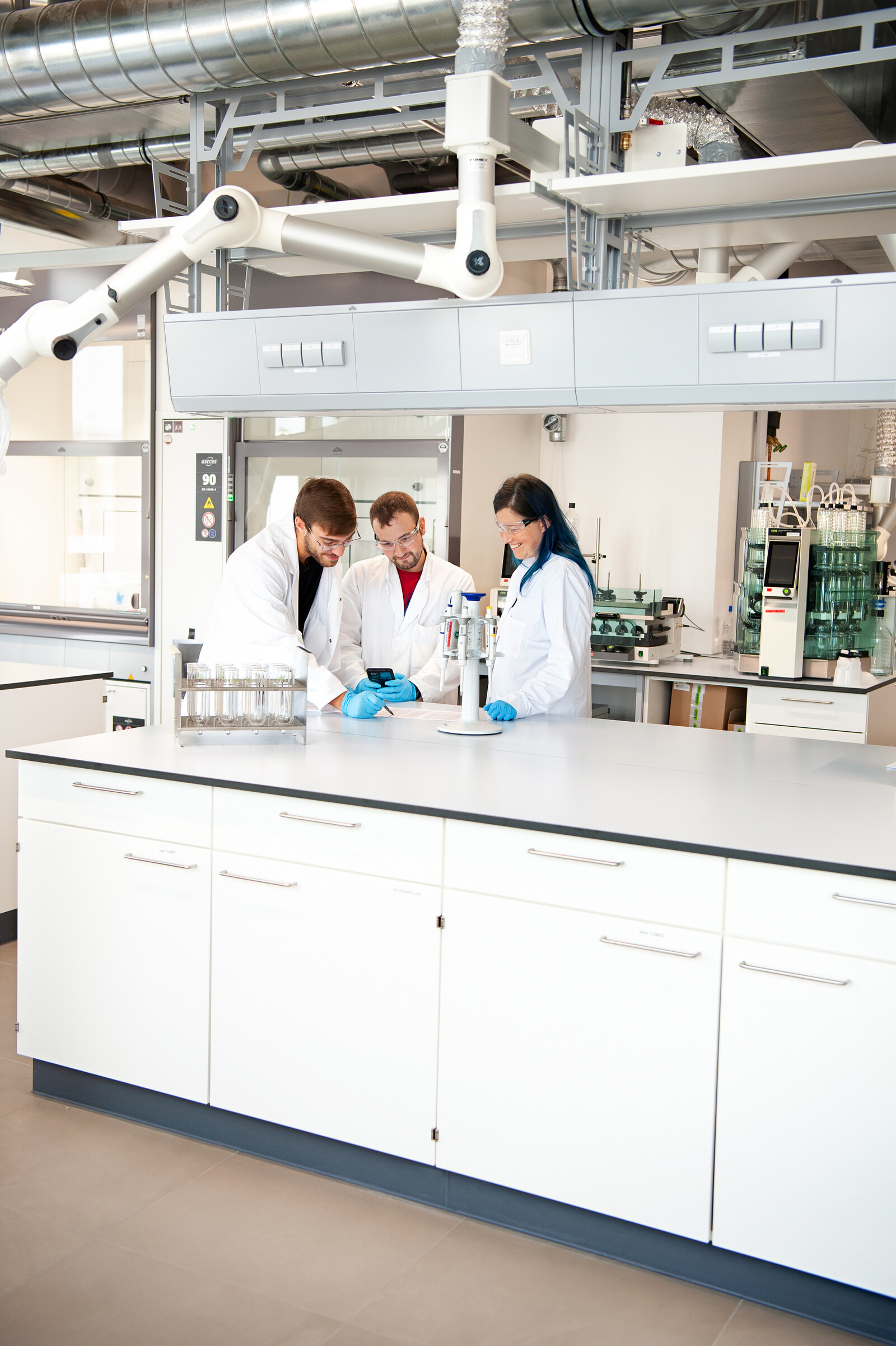 OETI laboratory: tree laboratory workers discussing test results