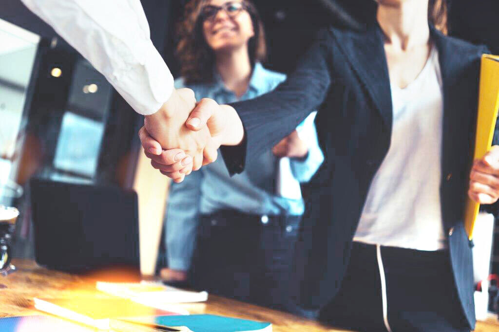 Our values: firm handshake three people