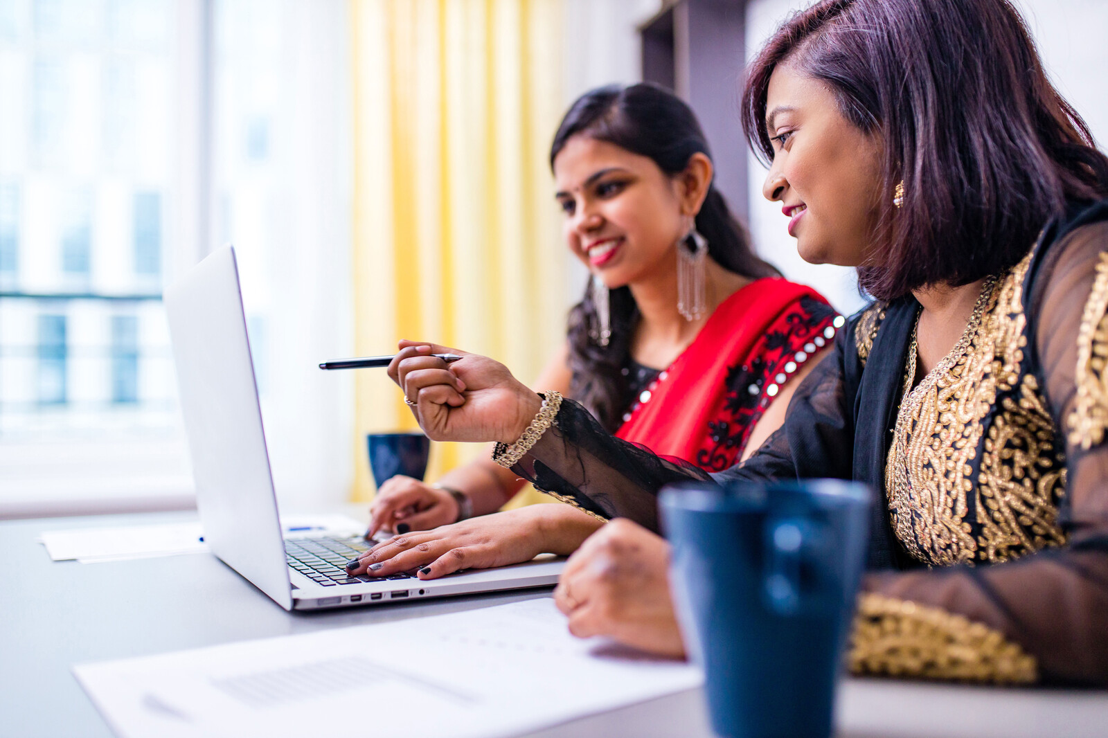 Our values: two Indian women looking at a laptop screen